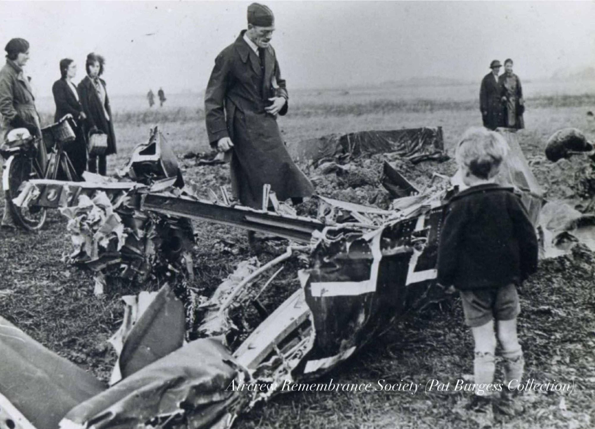 A very young boy studies the smashed wreckage of the Junkers. (Pat Burgess Collection)