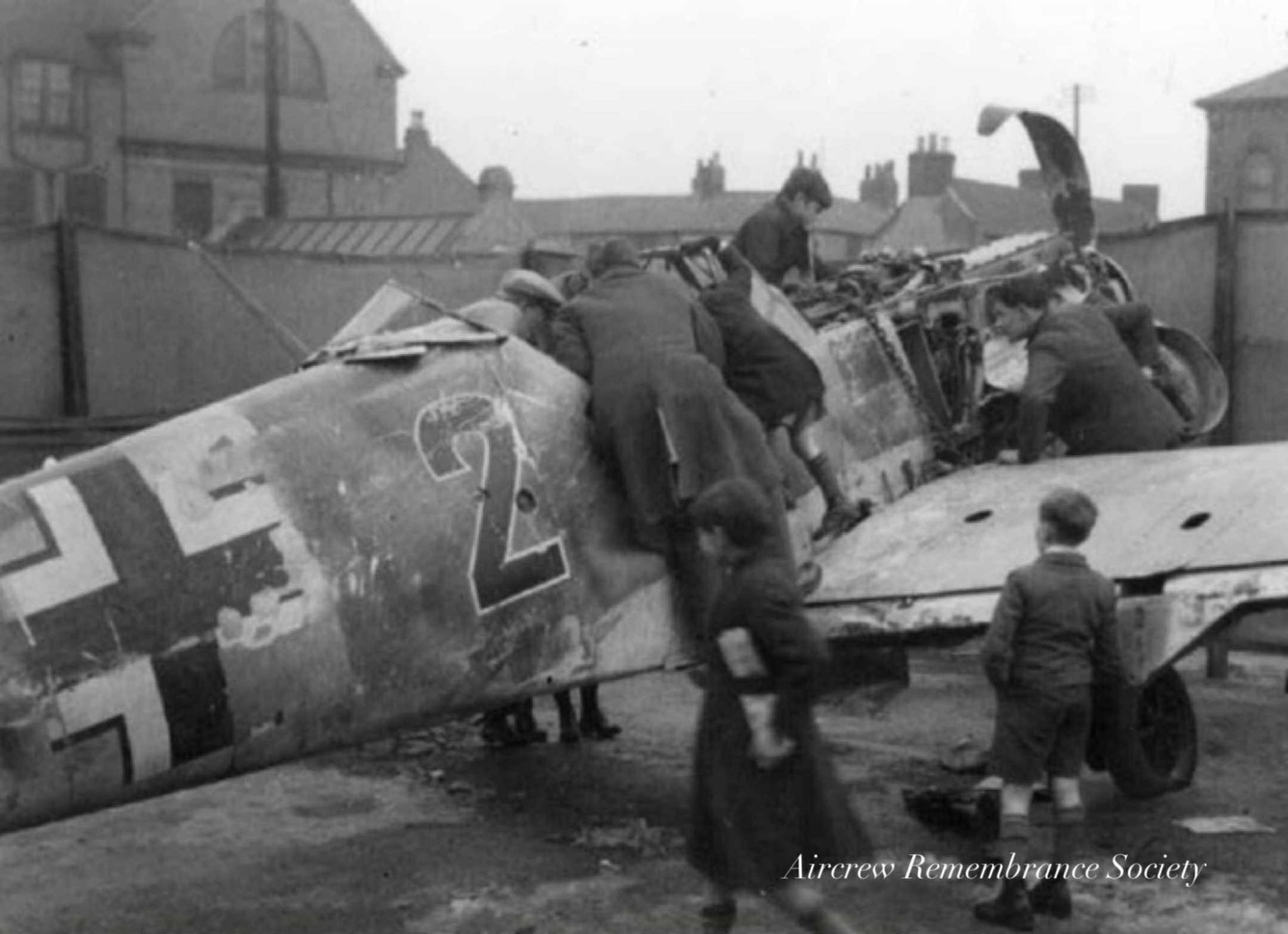School children climb over the wreck of Wagners Bf 109E whilst being displayed to the public.