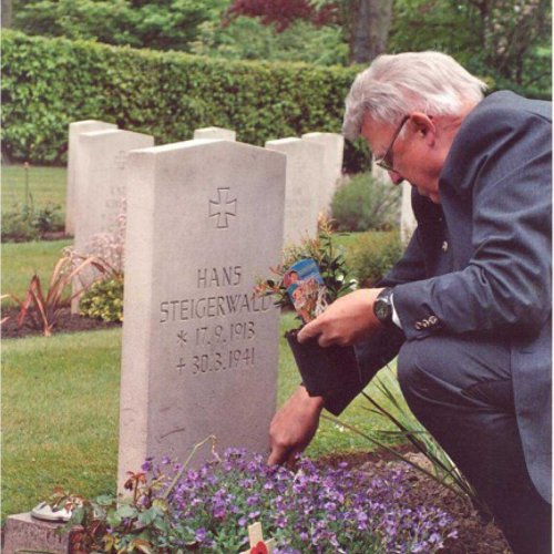 Heinz leaves a plant from Germany at his father’s grave. (Brownless)