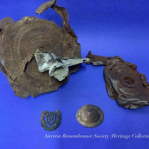 Collection of items now preserved in the society’s “Heritage Collection” from the crash site. Which include 20mm ammo drum, part or a saddle drum, badge and belt buckle.
