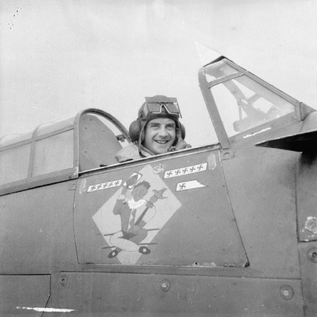 Squadron Leader J W C Simpson DFC, Commanding Officer of No. 245 Squadron RAF, seated in the cockpit of his Hawker Hurricane Mark I, W9145 'DX-L', at Aldergrove, County Antrim, on the day before he shot down his twelfth enemy aircraft.
Note Simpson's 'Jester' emblem below the cockpit.